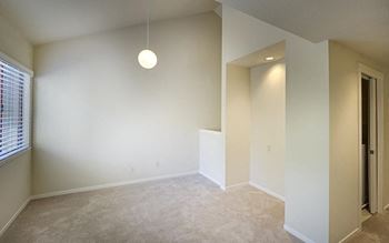 a large empty room with a pendant light hanging from the ceiling